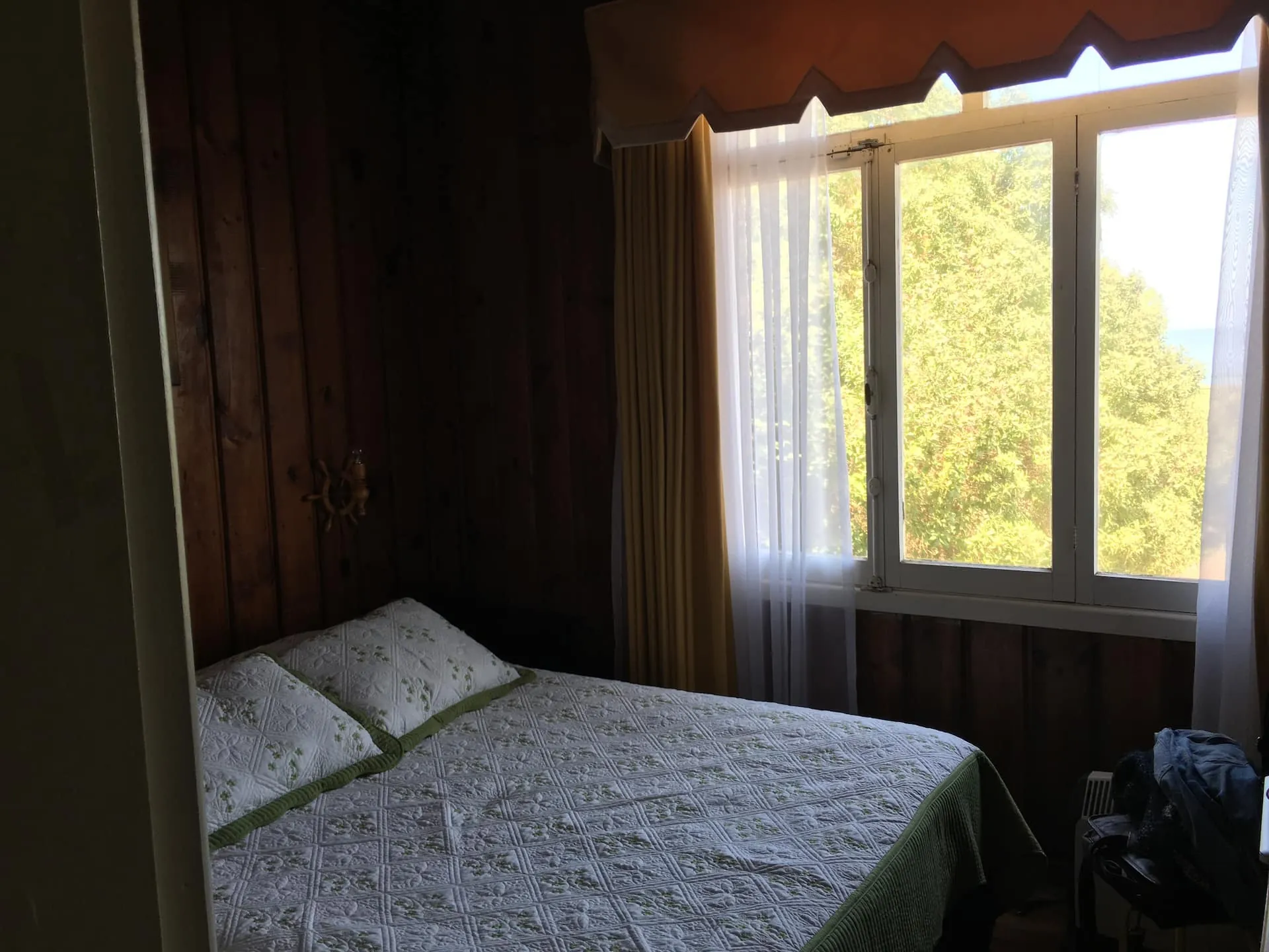 Dormitorio matrimonial de la casa principal con ventana al jardín